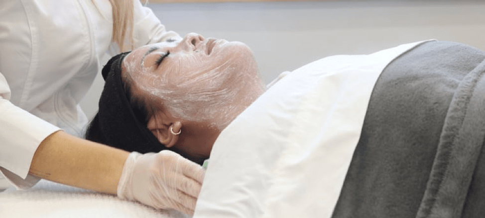 model getting a facial from a skin care specialist