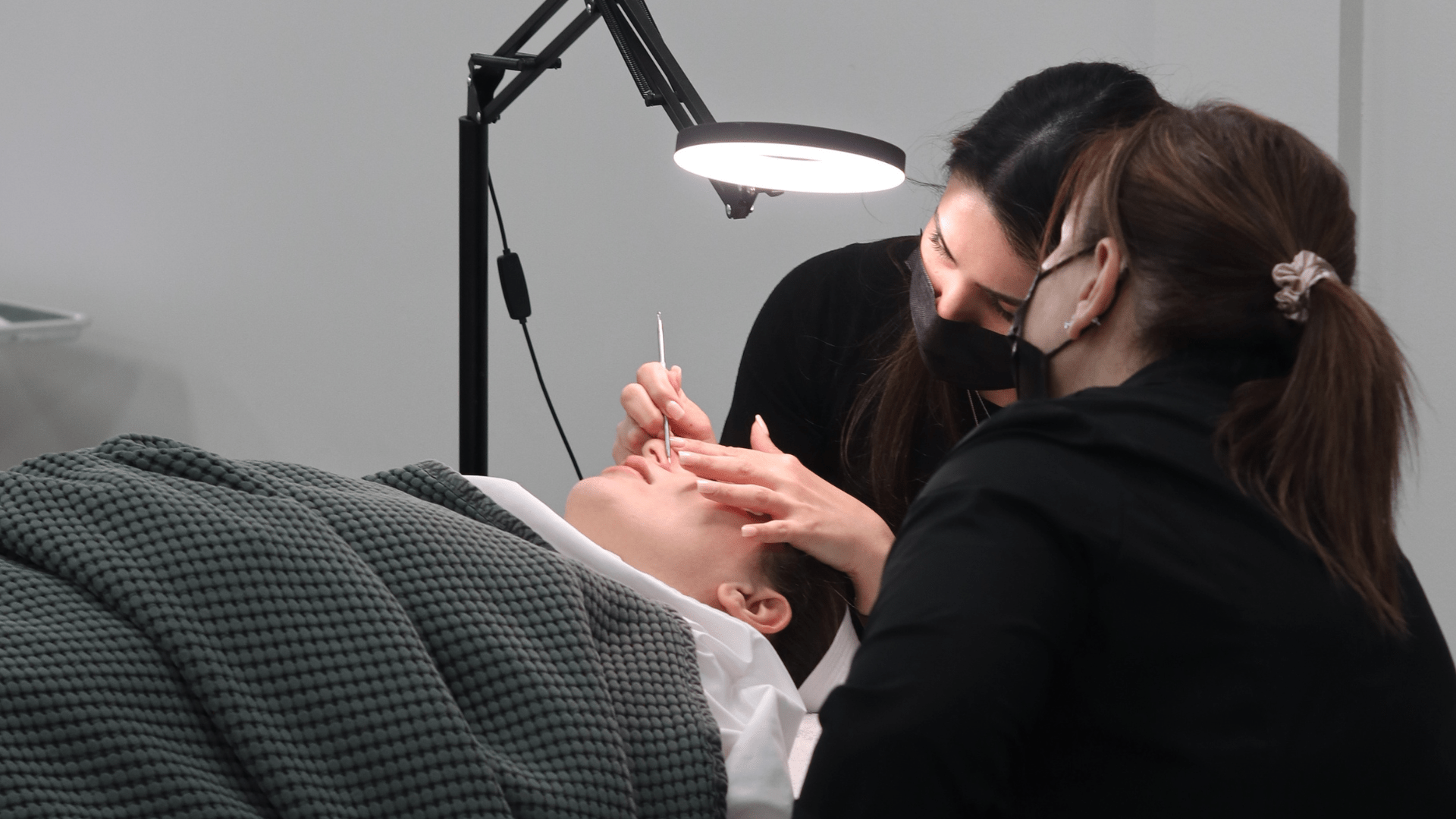 Student performing a facial under instructor supervision