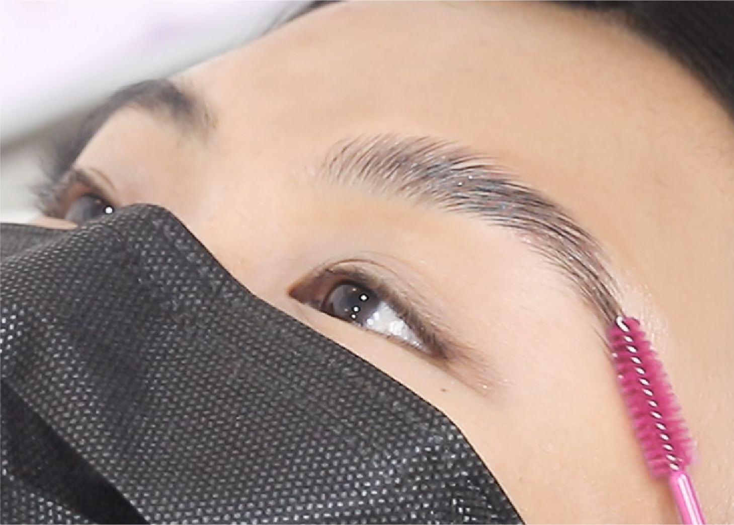 Brow spool combing through a person's eyebrow