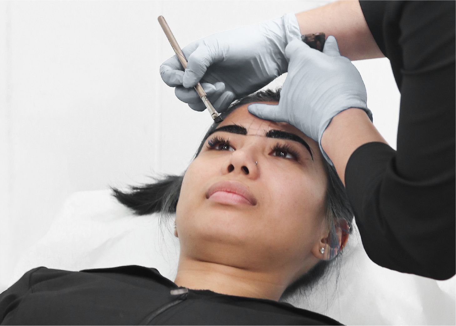 Student apply brow henna dye on model