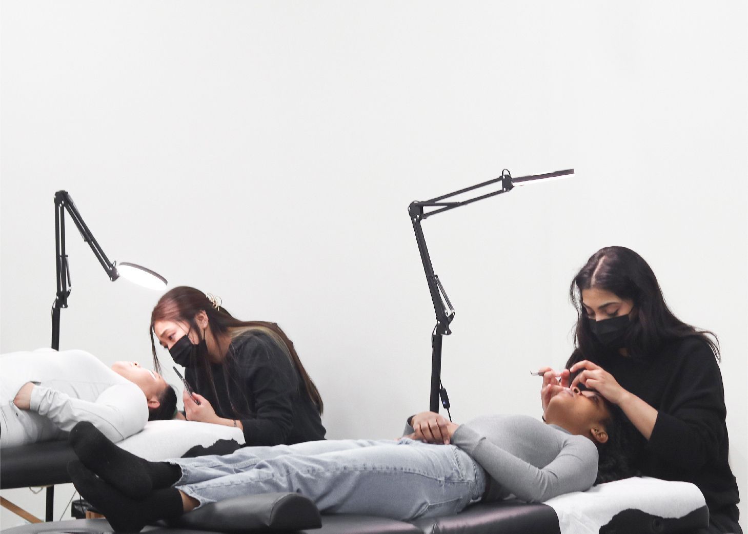 Lash technician students performing services on models at Wrapture Beauty Academy