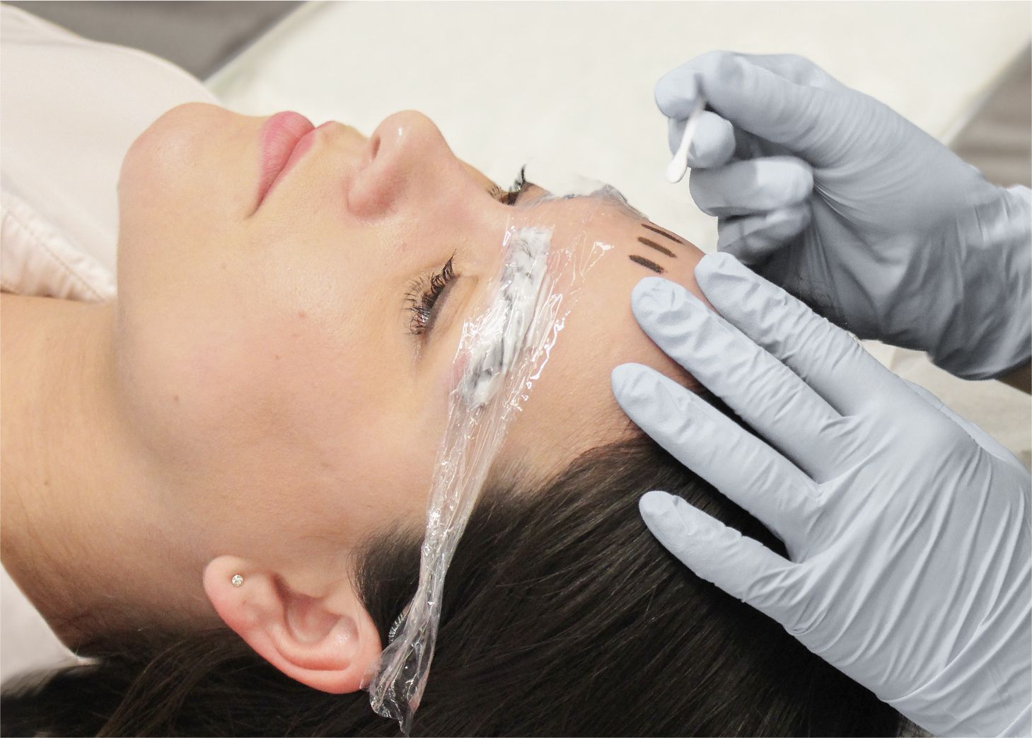 Student testing brow pigment colours on client