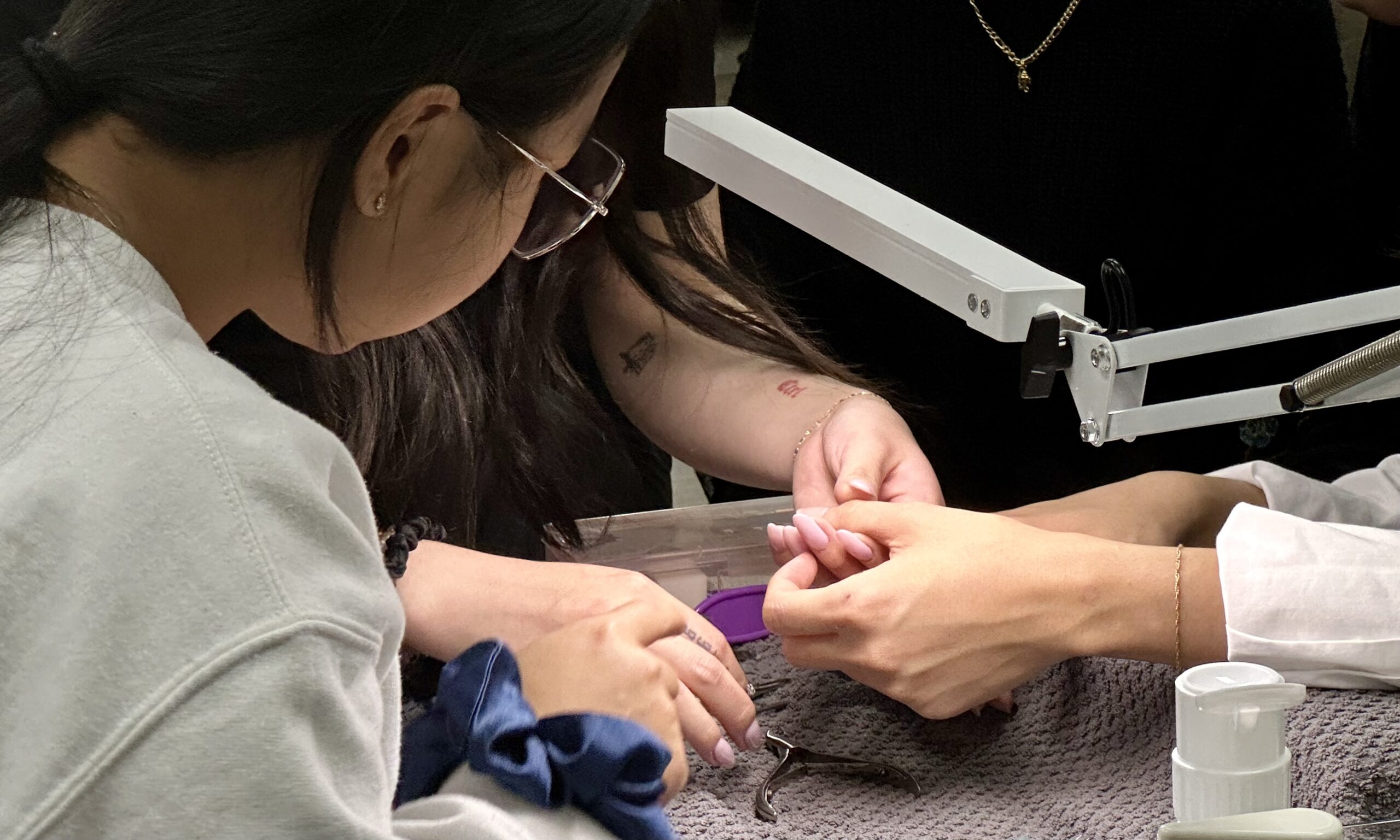 students practicing manicures on community member models
