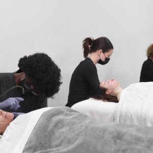 Wrapture Beauty Academy students performing facial services on clients