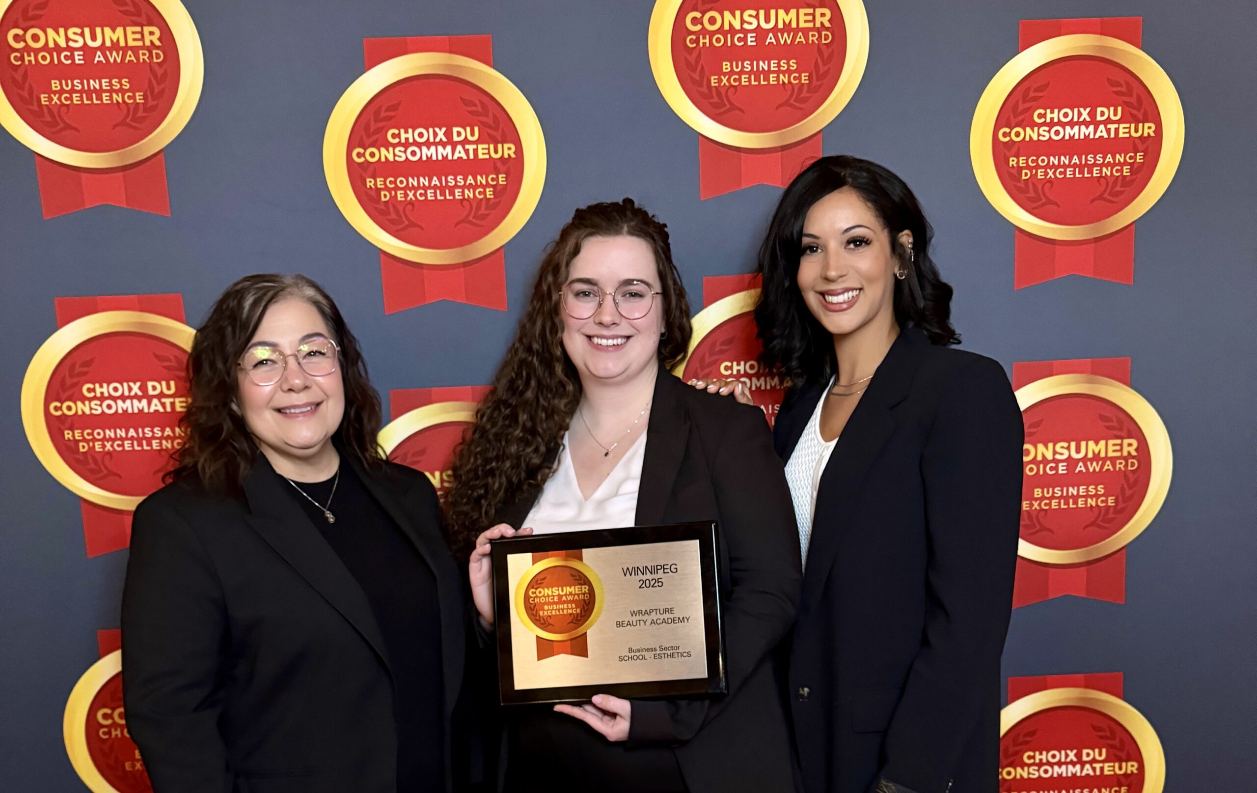 Three women dressed in black holding up an award.  Mel, Jenna, and Nathalie at the CCA Consumer Choice Awards 2025. 