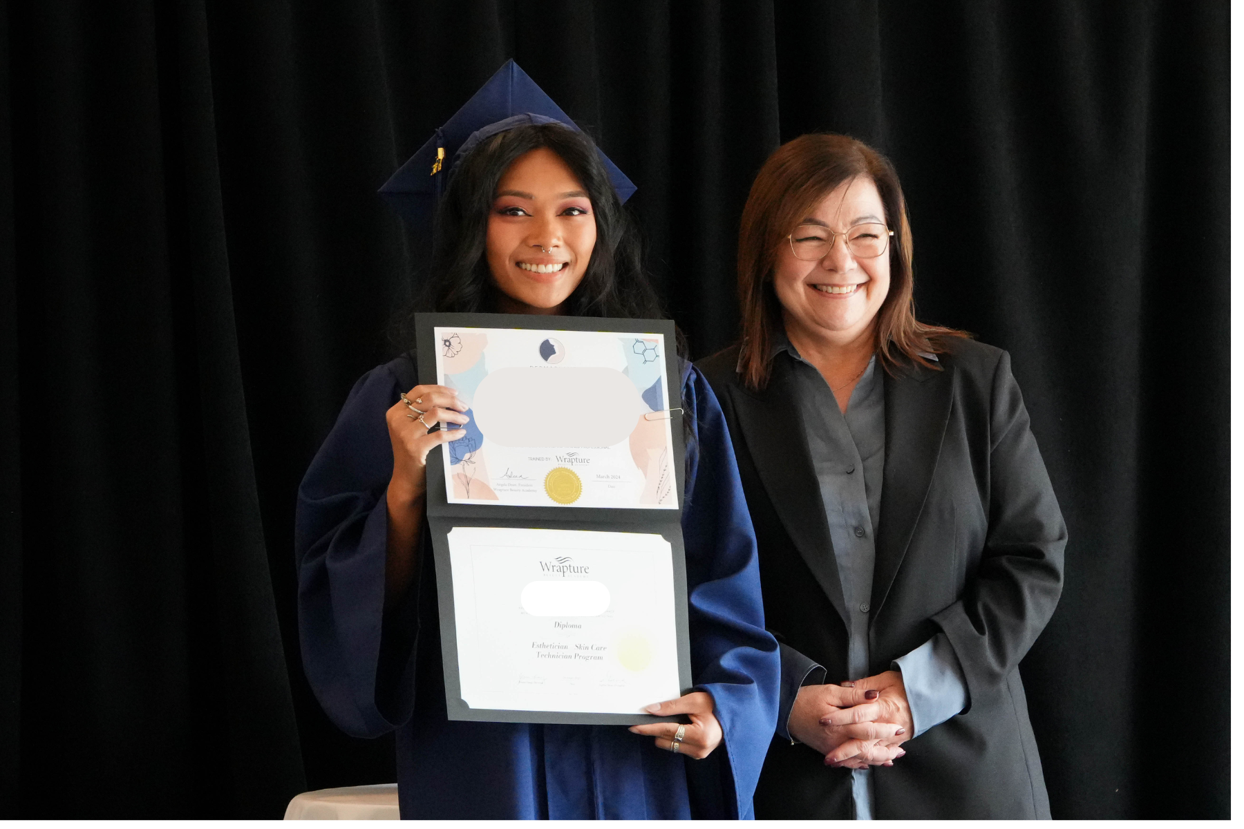 Graduate posing with faculty member at Wrapture Beauty Academy Winnipeg during their diploma ceremony.