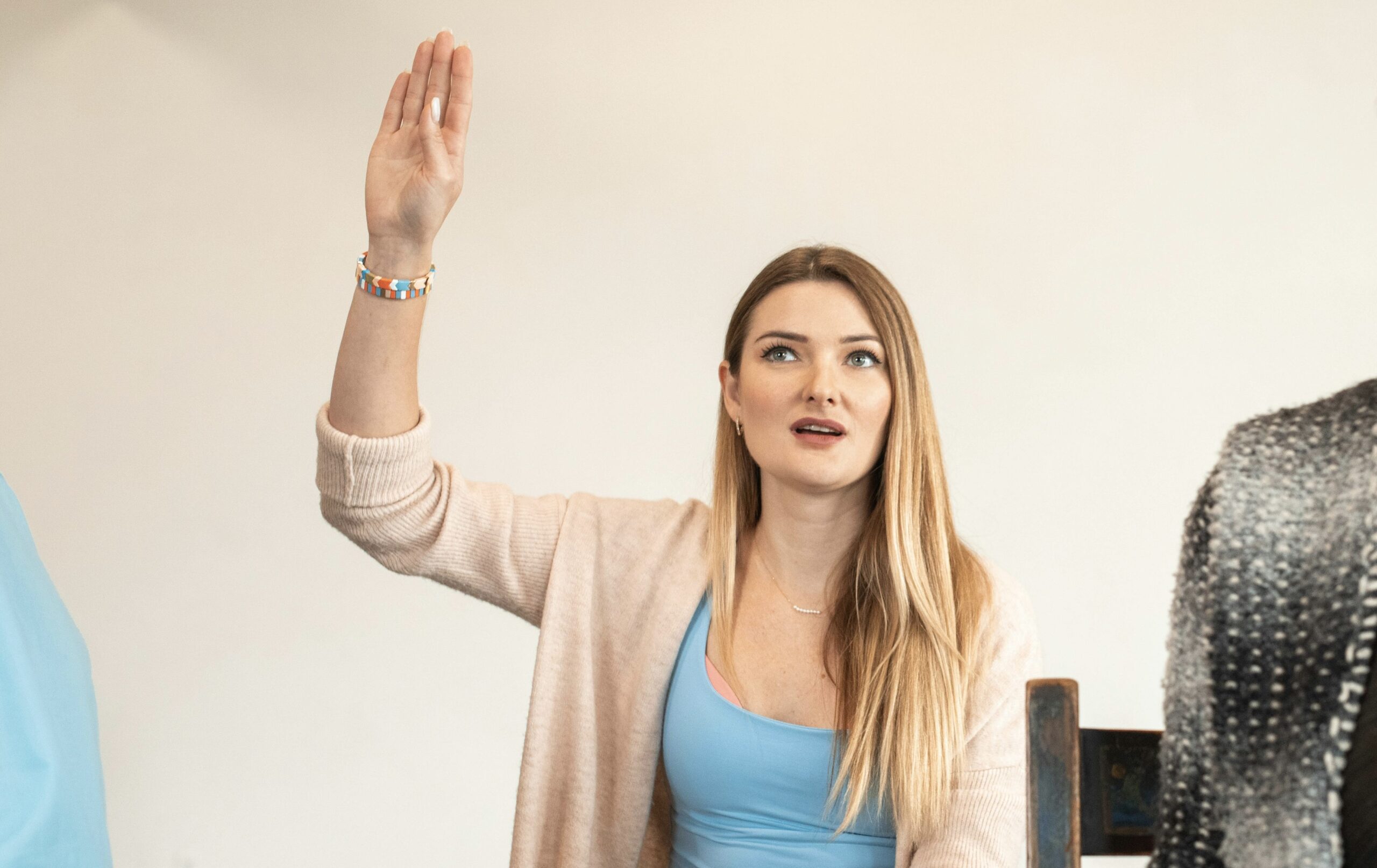 a prospective student raising her hand to ask a question about the esthetics program