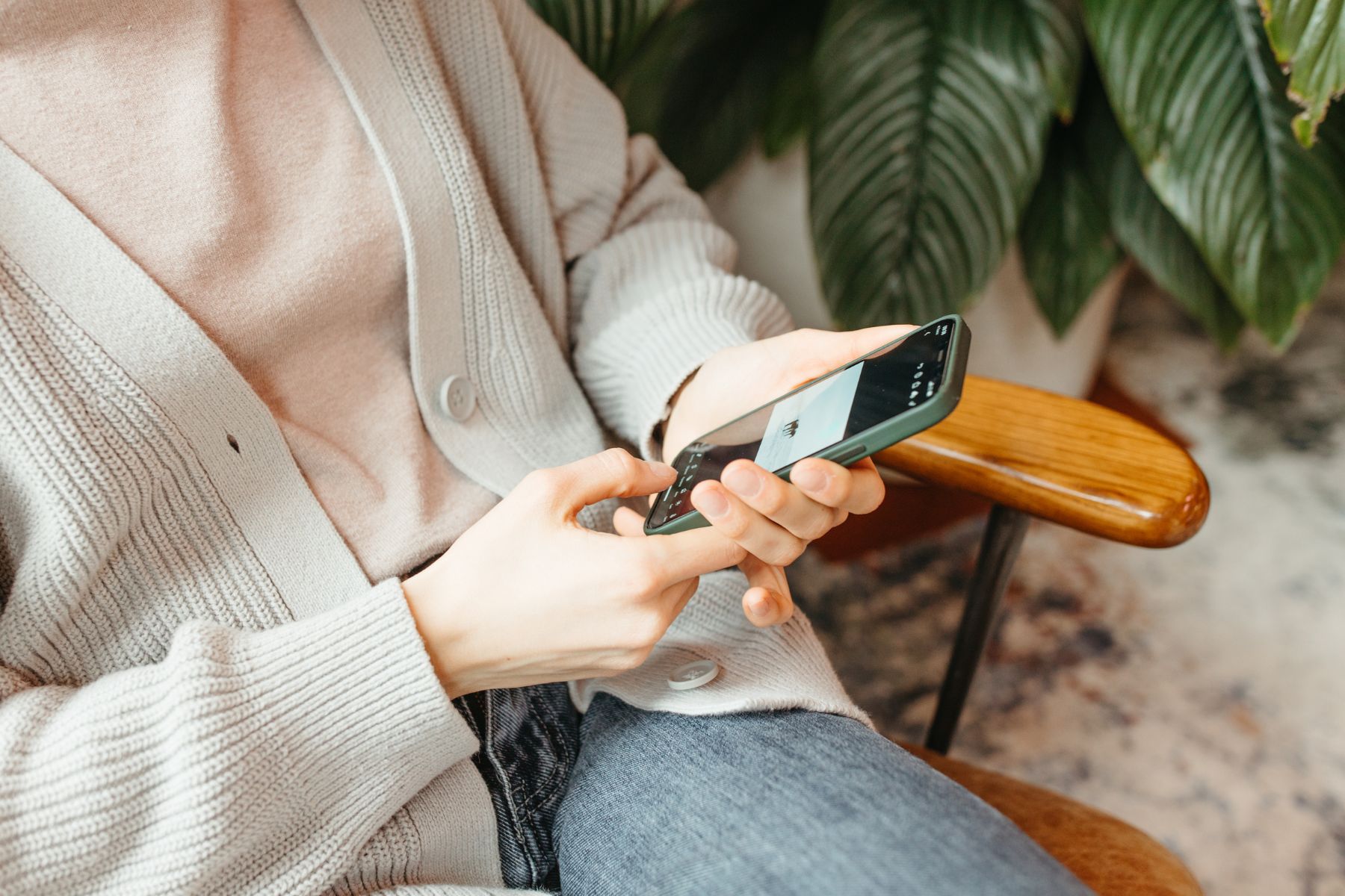Close-up of a person editing a photo on their smartphone, showing simple ways to batch content for social media for estheticians