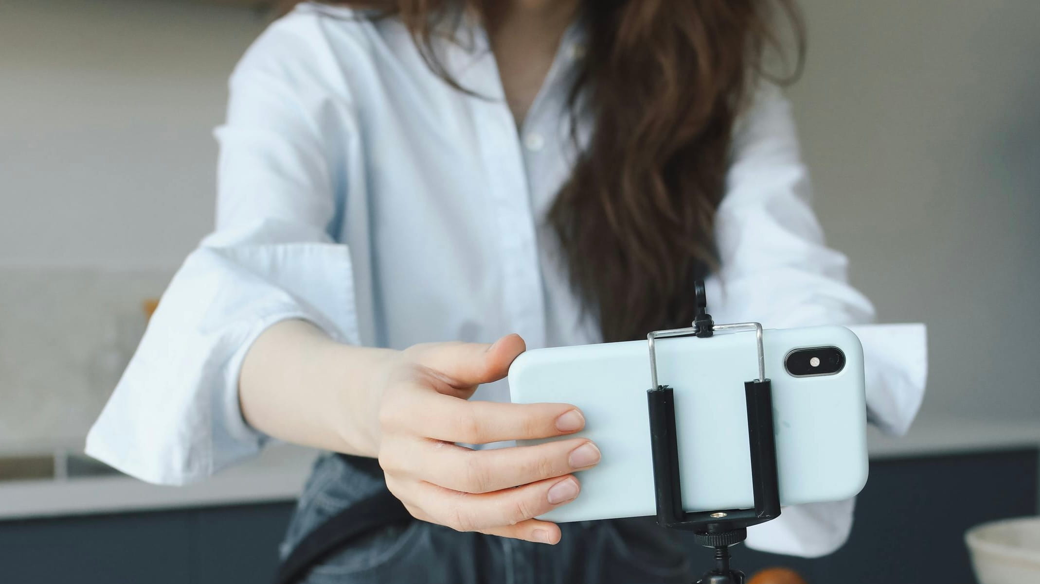 Esthetician setting up a phone to film, preparing short clips to educate clients in a Dermaplaning Spotlight.
